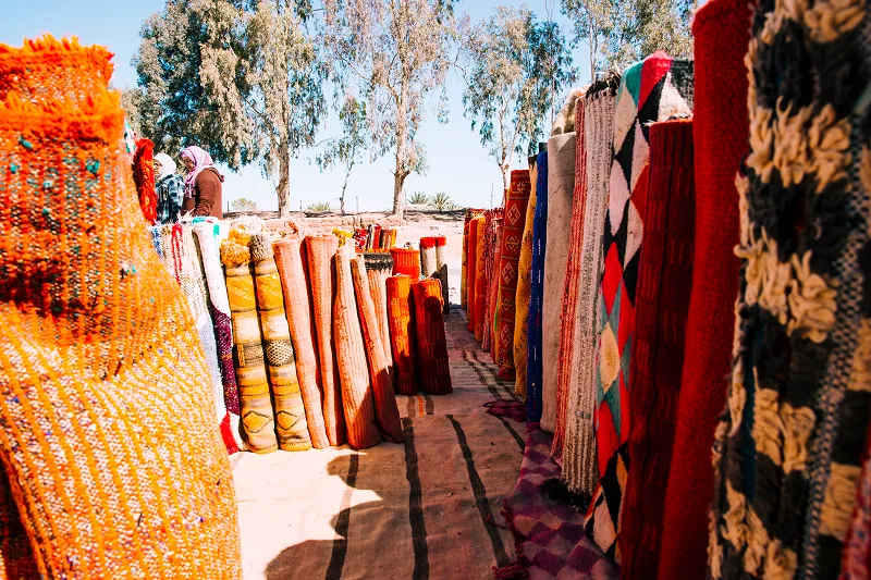 a group of colorful rugs on a rug stand
is berber carpet